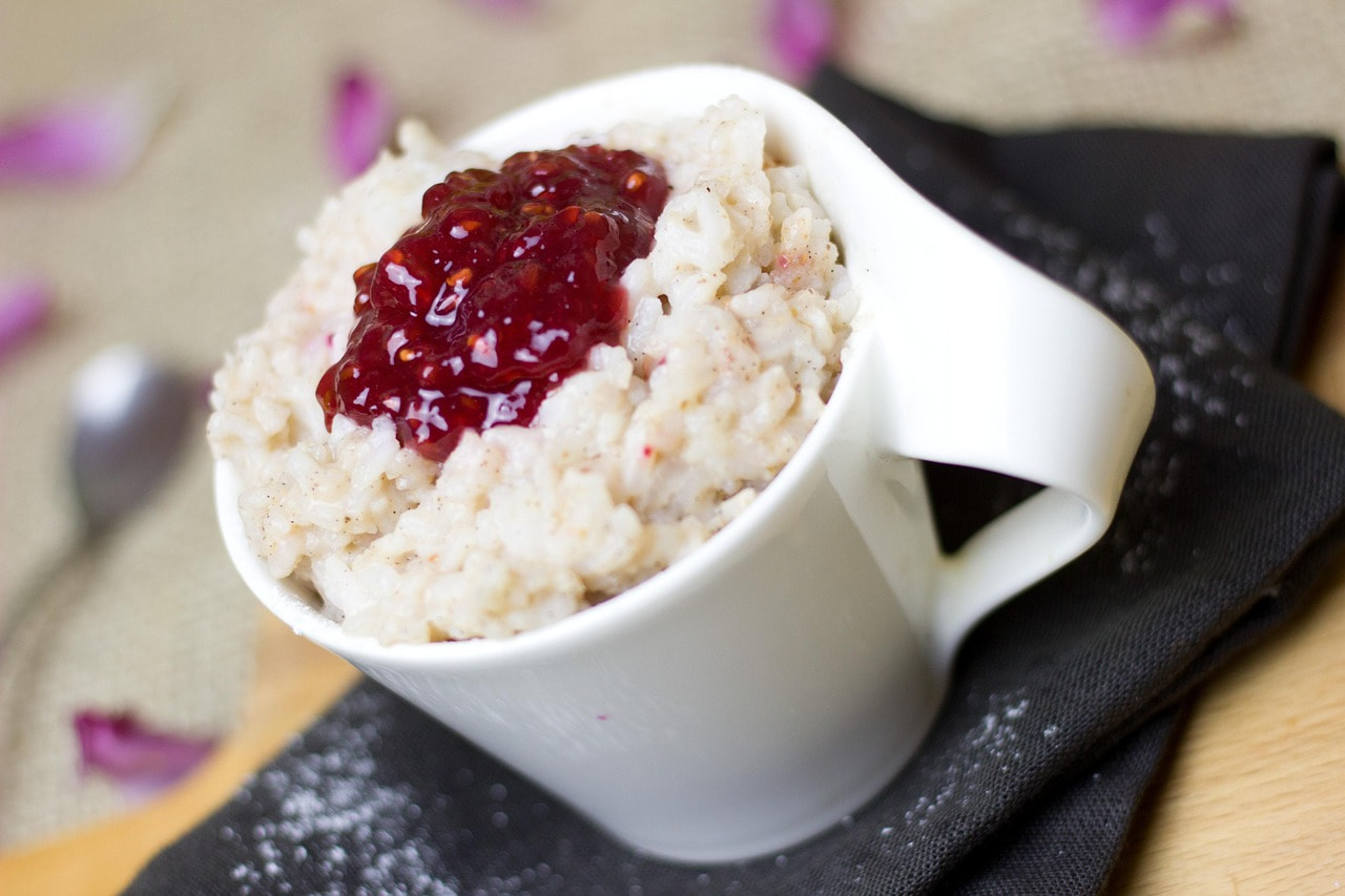 Colombian rice pudding in a cup with blackberry jam on the top