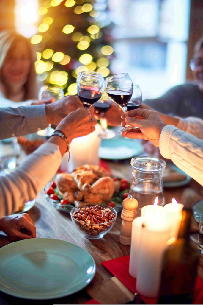 People raising wine glasses for a toast at a christmas dinner