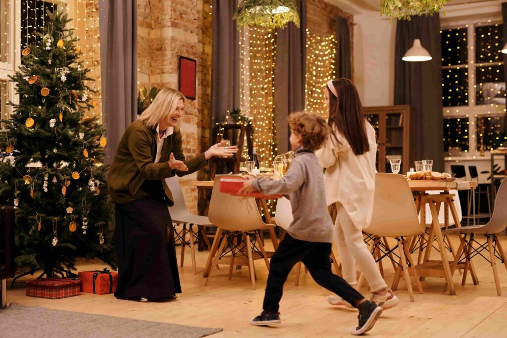 Kids running towards their grandmother in a warm home during christmas season