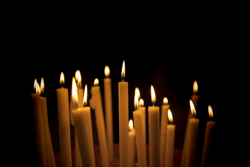 Small white candles burning in the dark