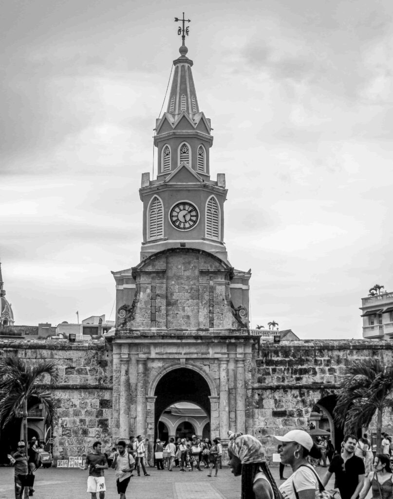Black and white photo of the Walled City entrance in Cartagena with people walking.