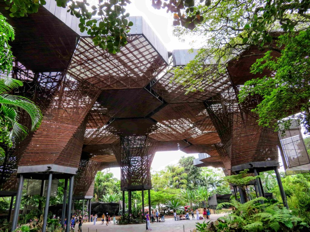 Modern wooden architecture at the Medellín Botanical Garden surrounded by trees in Colombia.