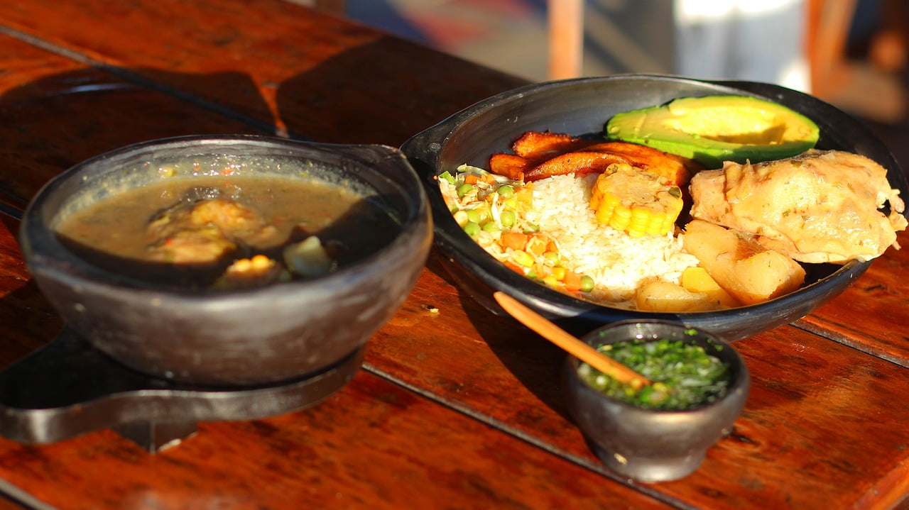 Traditional Colombian sancocho soup served with a side plate of rice and chicken.